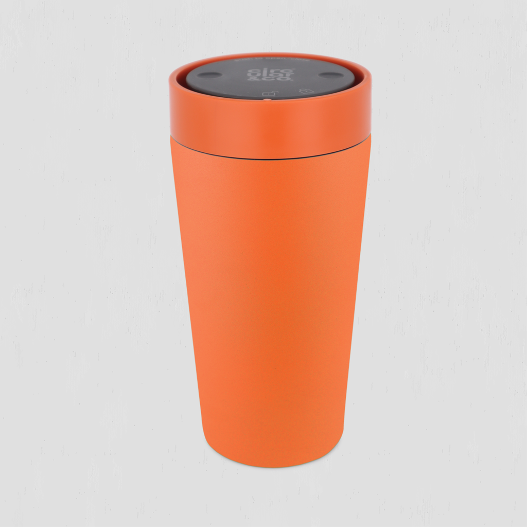 An orange travel tumbler with a matching orange lid and a dark gray top control panel, shown on a light gray background.