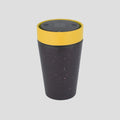 A reusable insulated tumbler with a dark speckled body, a bright yellow band around the upper portion, and a dark gray lid, shown on a solid light gray background.