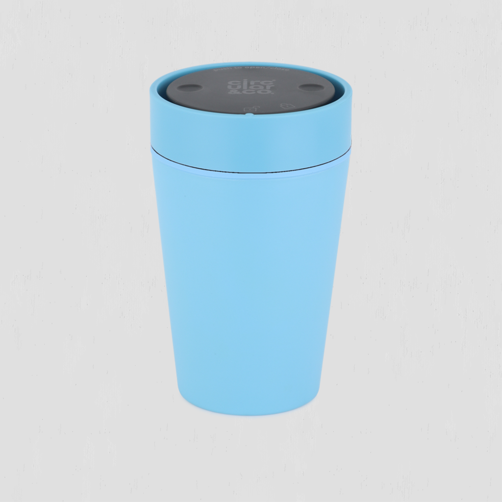 A light blue cylindrical travel cup with a dark gray lid, shown on a light gray background.