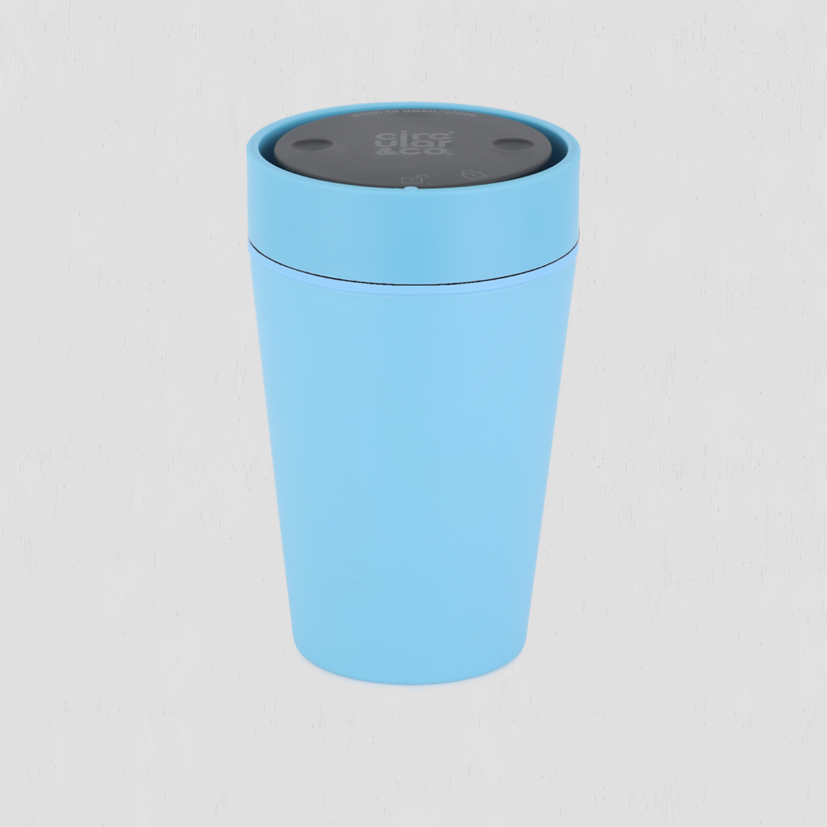 A light blue cylindrical travel cup with a dark gray lid, shown on a light gray background.