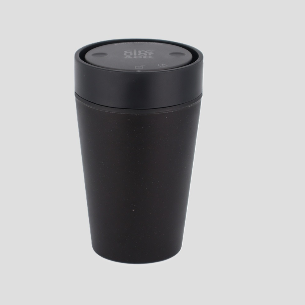 A matte black travel tumbler with a matching black screw-on lid, shown on a solid light gray background.