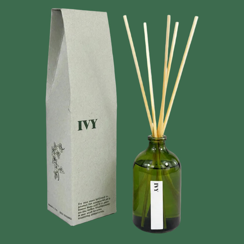 Green diffuser bottle with wooden sticks and gray packaging labeled 'IVY' 