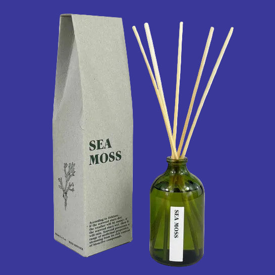 Green diffuser bottle with wooden sticks and 'Sea Moss' packaging.