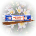 Nag Champa incense sticks with packaging on a white floral background
