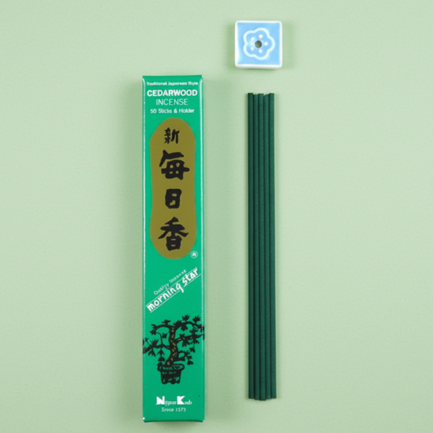 Green incense packaging with incense sticks on a green background
