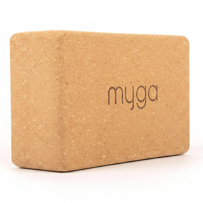 A beige cork yoga block with the brand name 'myga' printed on the front.