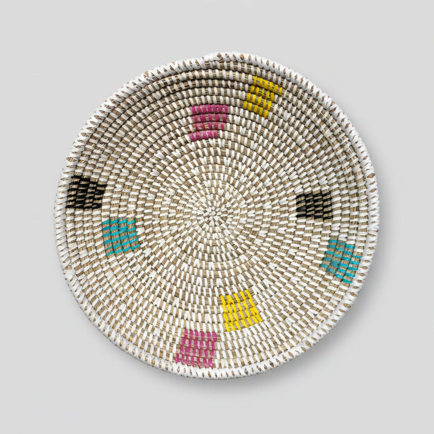 a round woven bowl, white with multi colour sqaure 