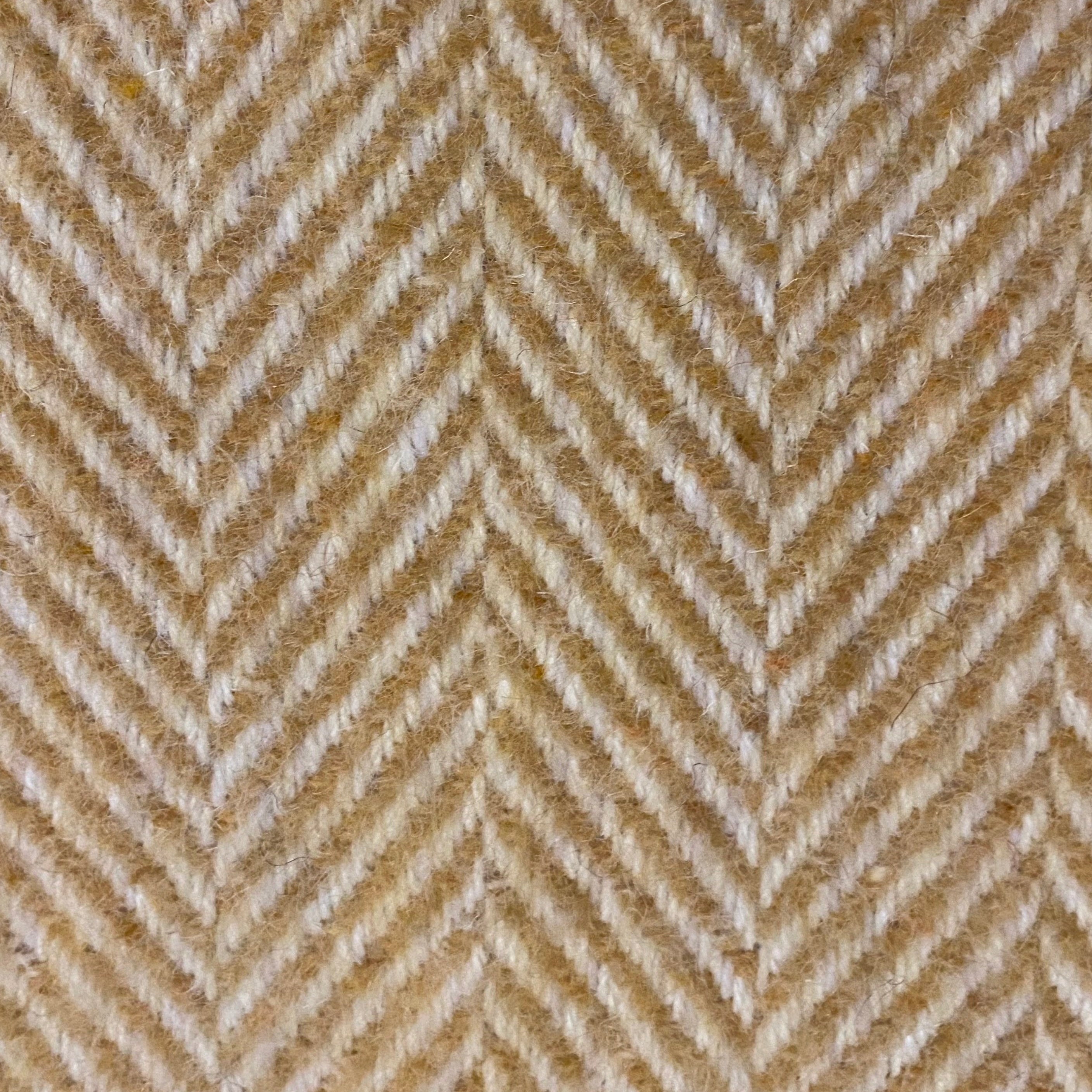 Textured fabric with a herringbone pattern in beige and gold tones.