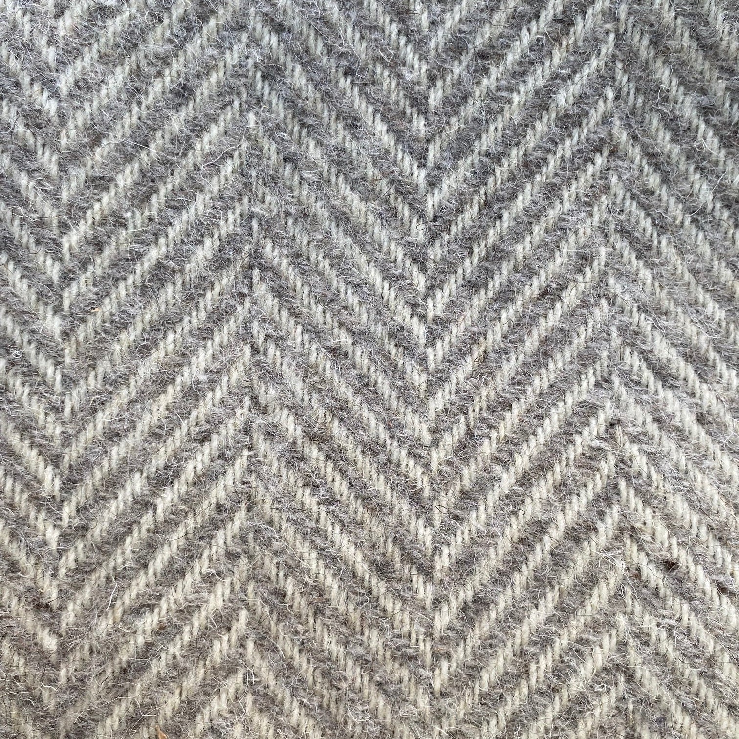 Close-up of a gray blanket with a herringbone pattern