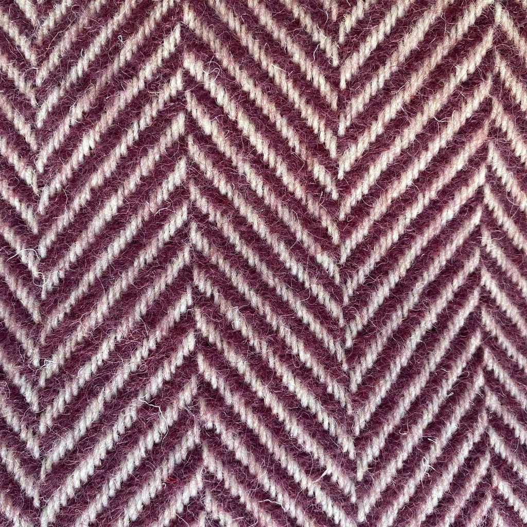 Close-up of a blanket with a zigzag pattern in purple and white.