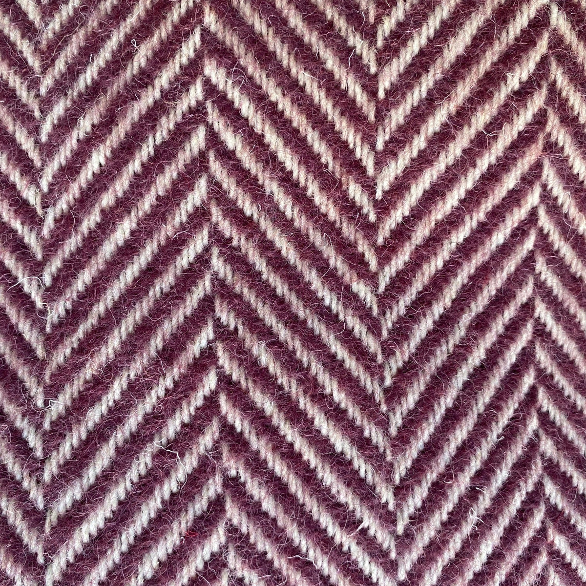 Close-up of a blanket with a zigzag pattern in purple and white.