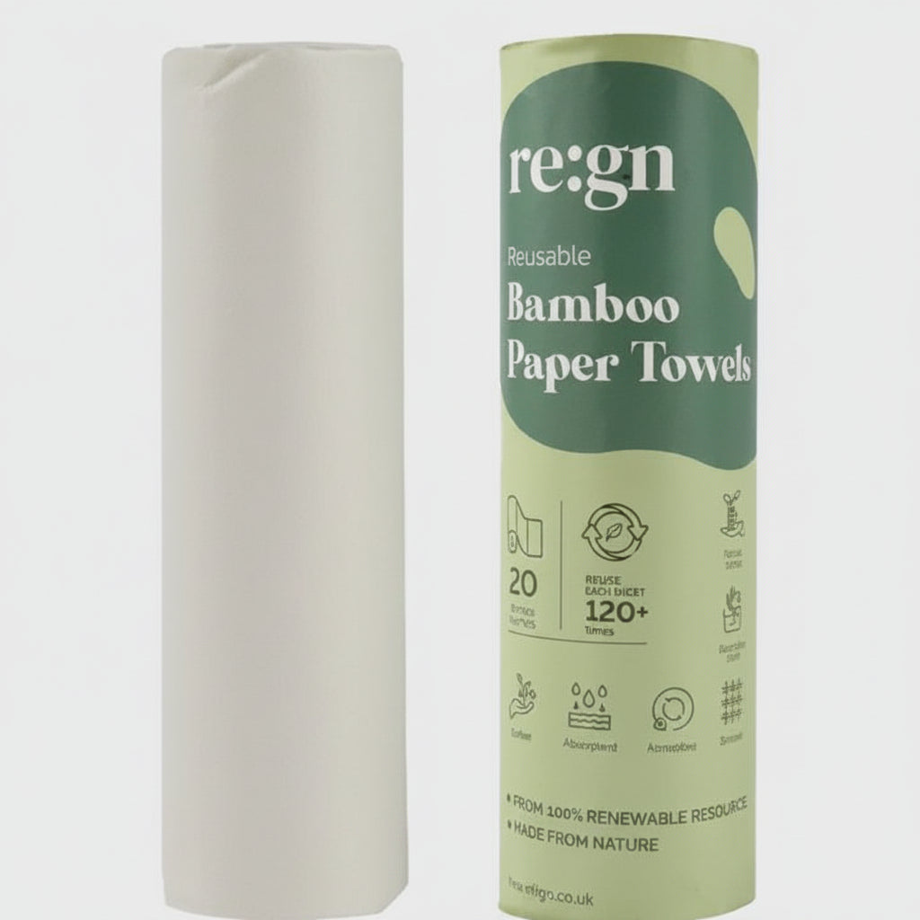 Roll of white paper towels next to a green and white 'reign' branded box on a light gray background