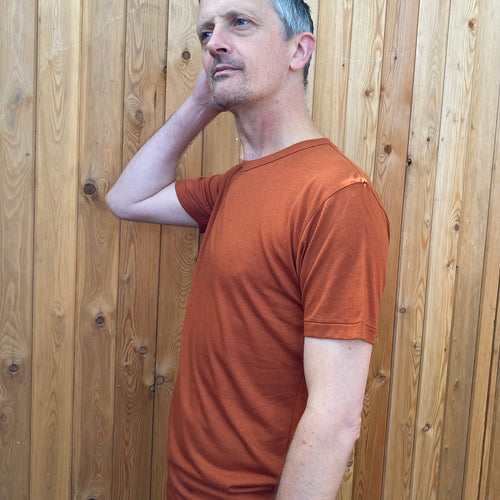 a man wearing a burnt orange t shirt