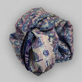 Rolled-up scarf with a blue pattern on a beige background