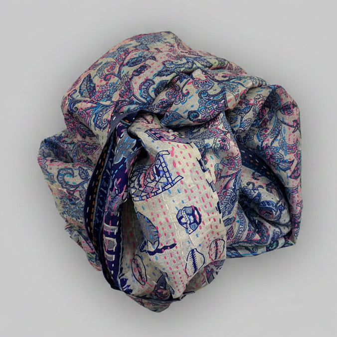 Rolled-up scarf with a blue pattern on a beige background