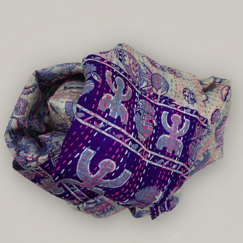 Folded fabric with blue and pink patterns on a beige background