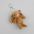 A plush brown bunny keychain with long floppy ears, a silver metal clasp, and a round red and silver tag, shown on a plain white background.