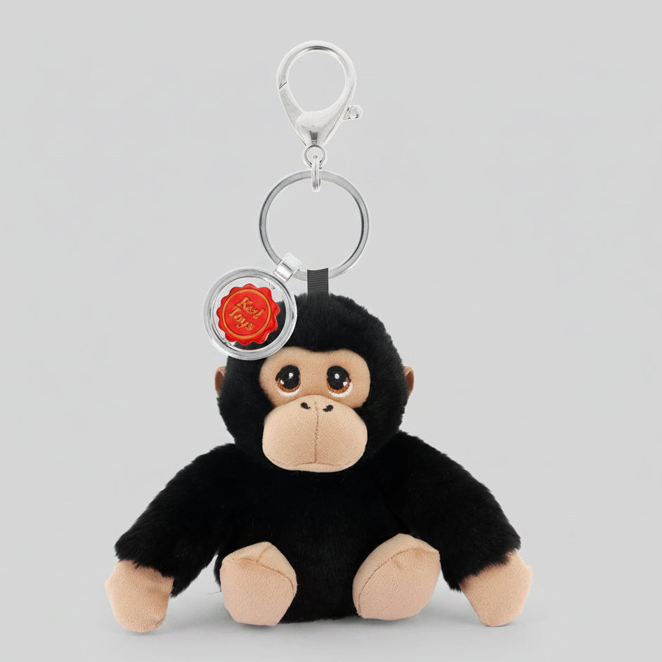 Plush monkey keychain with a red emblem on a white background