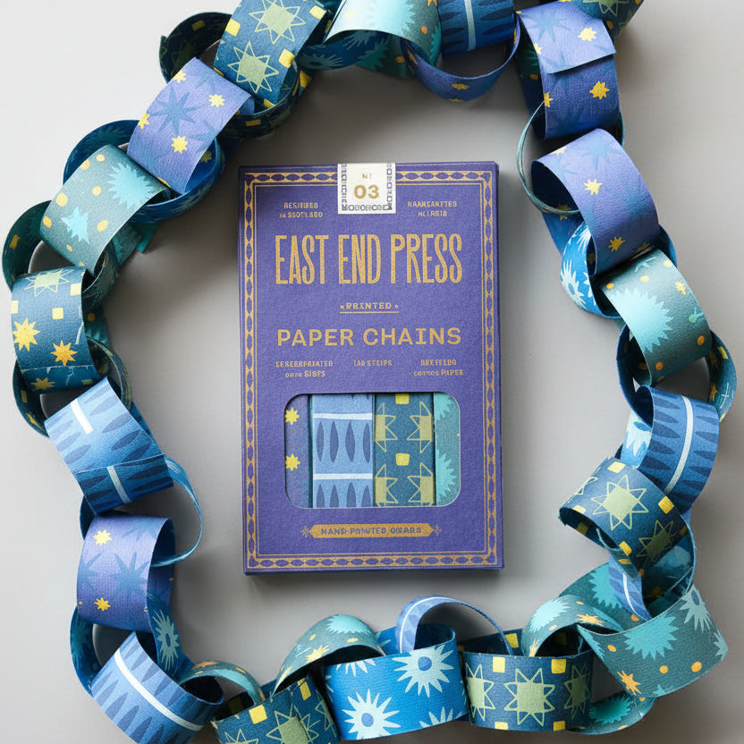 East End Press paper chains packaging on a wooden surface with decorative ribbons.