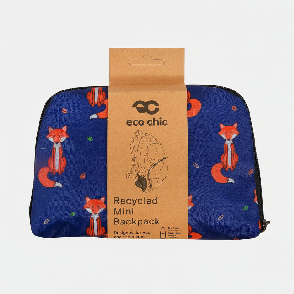 A blue mini backpack with a fox pattern, wrapped in a brown cardboard sleeve labeled 'eco chic Recycled Mini Backpack' on a white background.