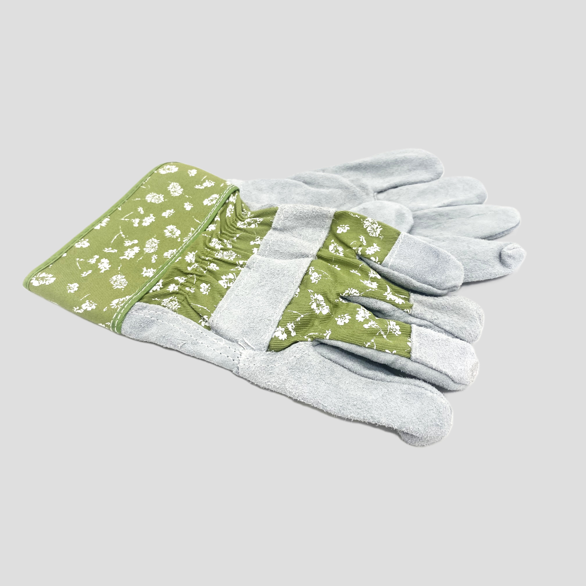 A pair of gardening gloves with sage green fabric palms and cuffs decorated with a white floral pattern, and light gray textured fabric on the fingers and backs, shown on a solid gray background.