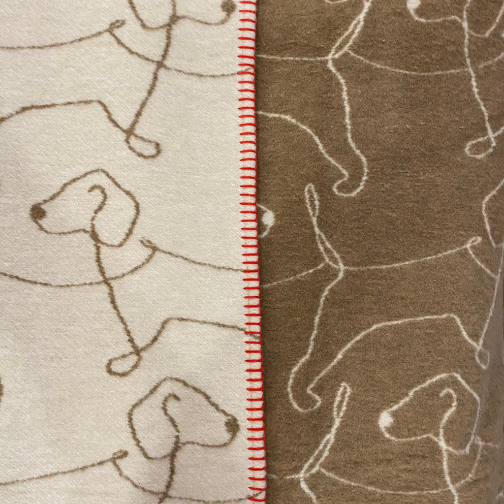 blanket , cream and brown with a repeated  line design of a dog