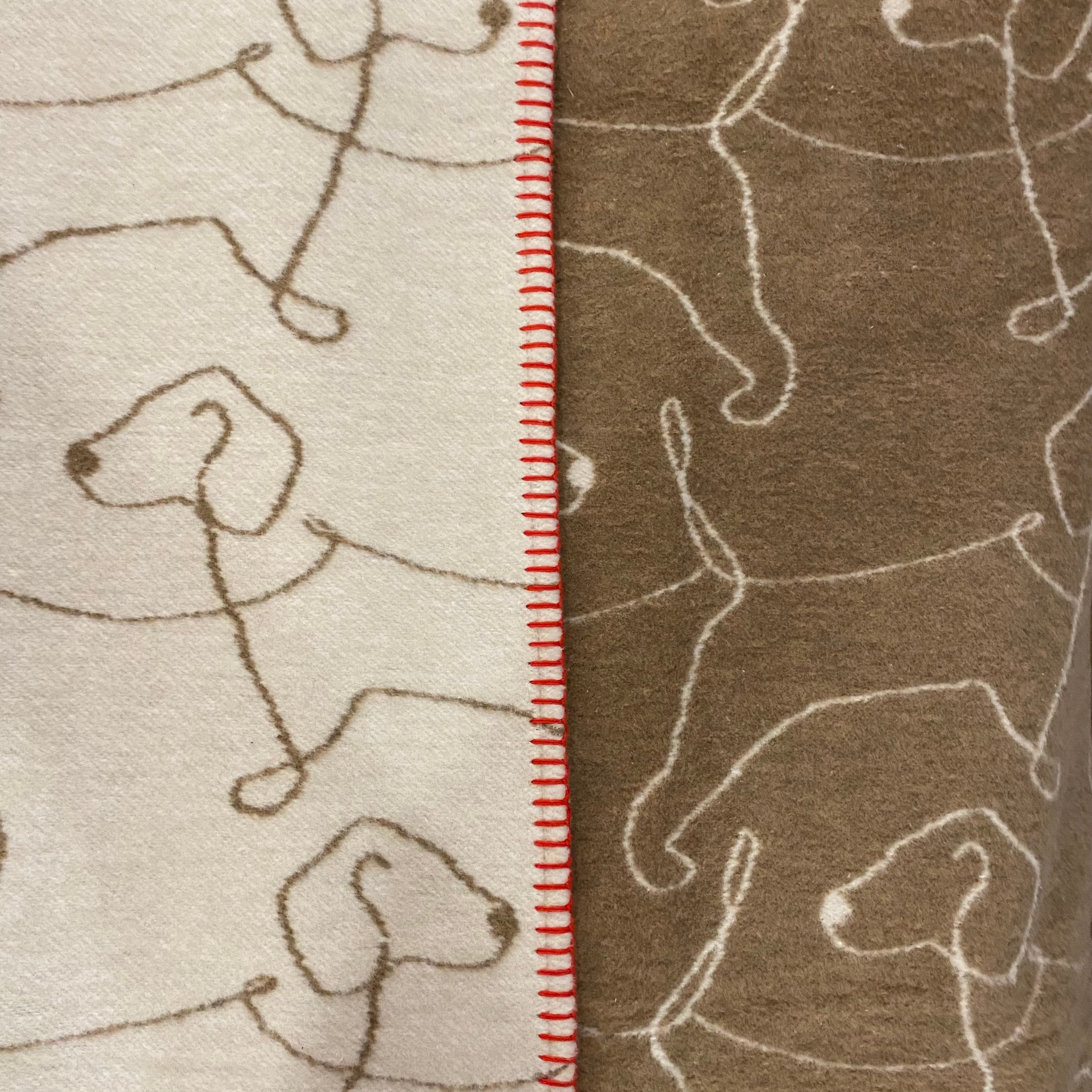 blanket , cream and brown with a repeated  line design of a dog