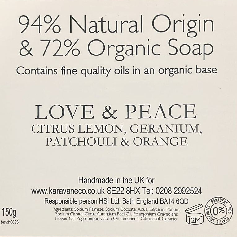 A brown kraft paper soap bar package with a white label reading '94% Natural Origin & 72% Organic Soap' and 'LOVE & PEACE' on a wooden surface.