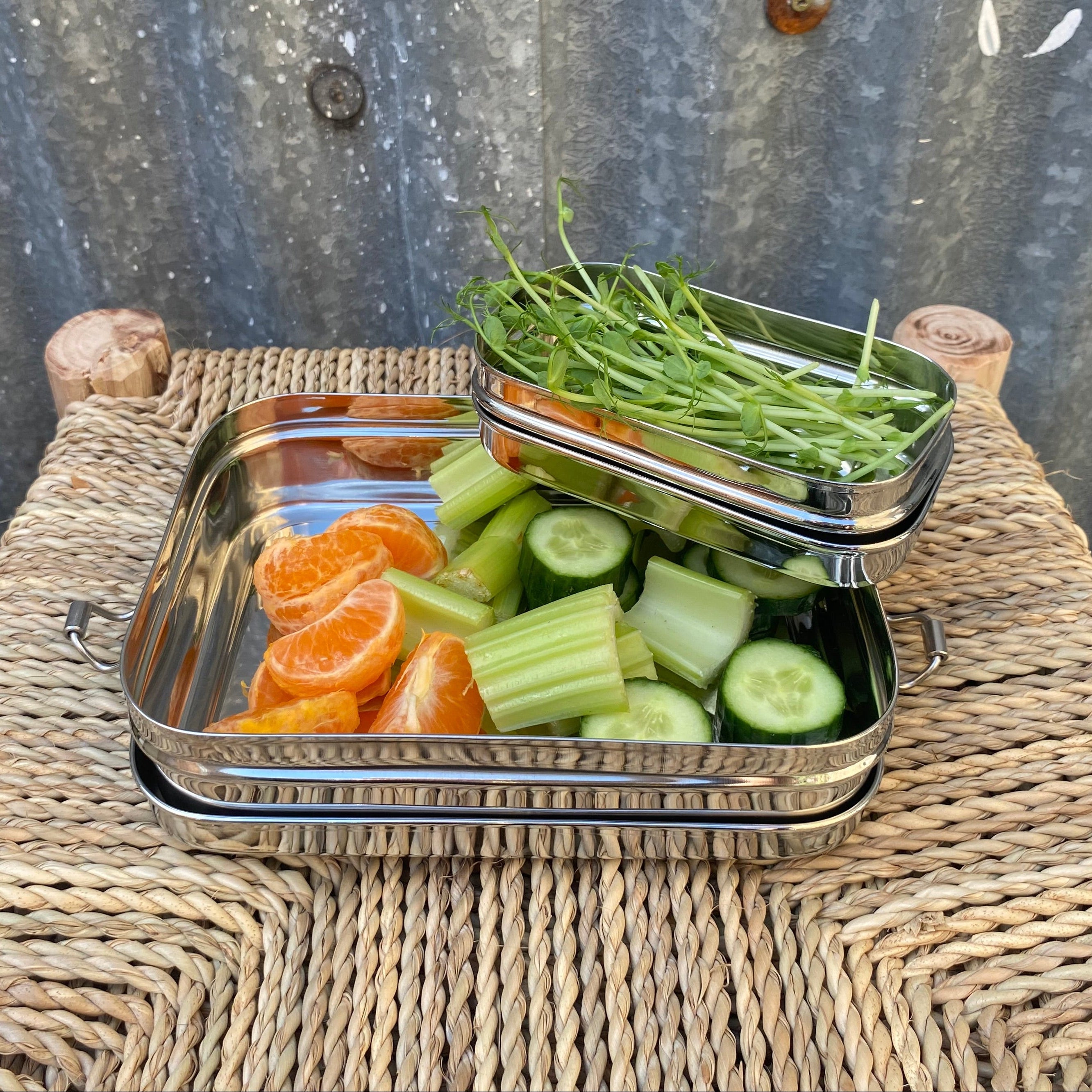 Two stacked stainless steel lunch boxes. 