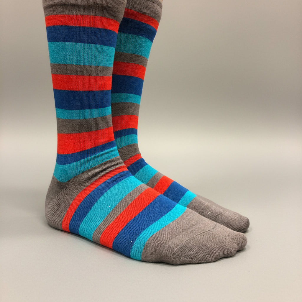 A pair of crew socks with horizontal stripes in gray, blue, teal, and red, shown on a neutral light gray background.