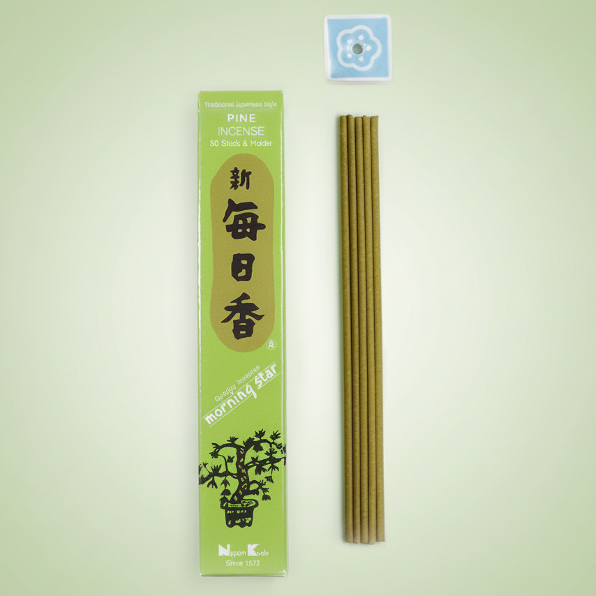 Incense sticks with green packaging on a pale green background