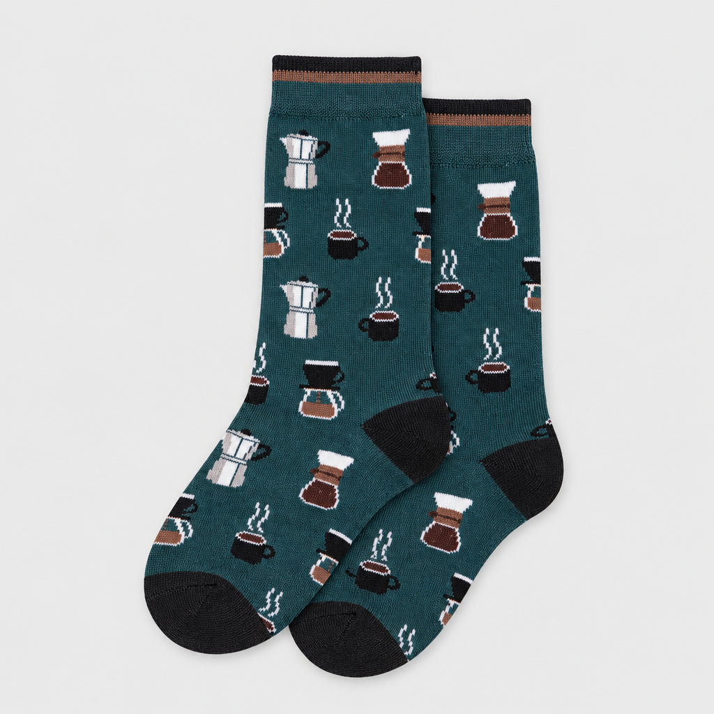 A pair of crew socks in a dark teal green color, featuring a repeating pattern of coffee-themed illustrations including moka pots, pour-over coffee makers, and steaming coffee cups. The socks have black and brown striped ribbed cuffs and heels, and solid black toes and heels.