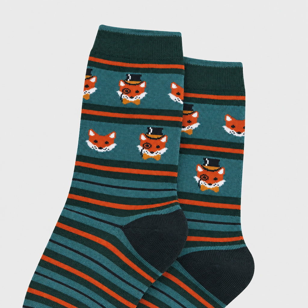 A pair of dark teal crew socks with horizontal orange stripes and cartoon fox faces wearing top hats, shown on a plain grey background.