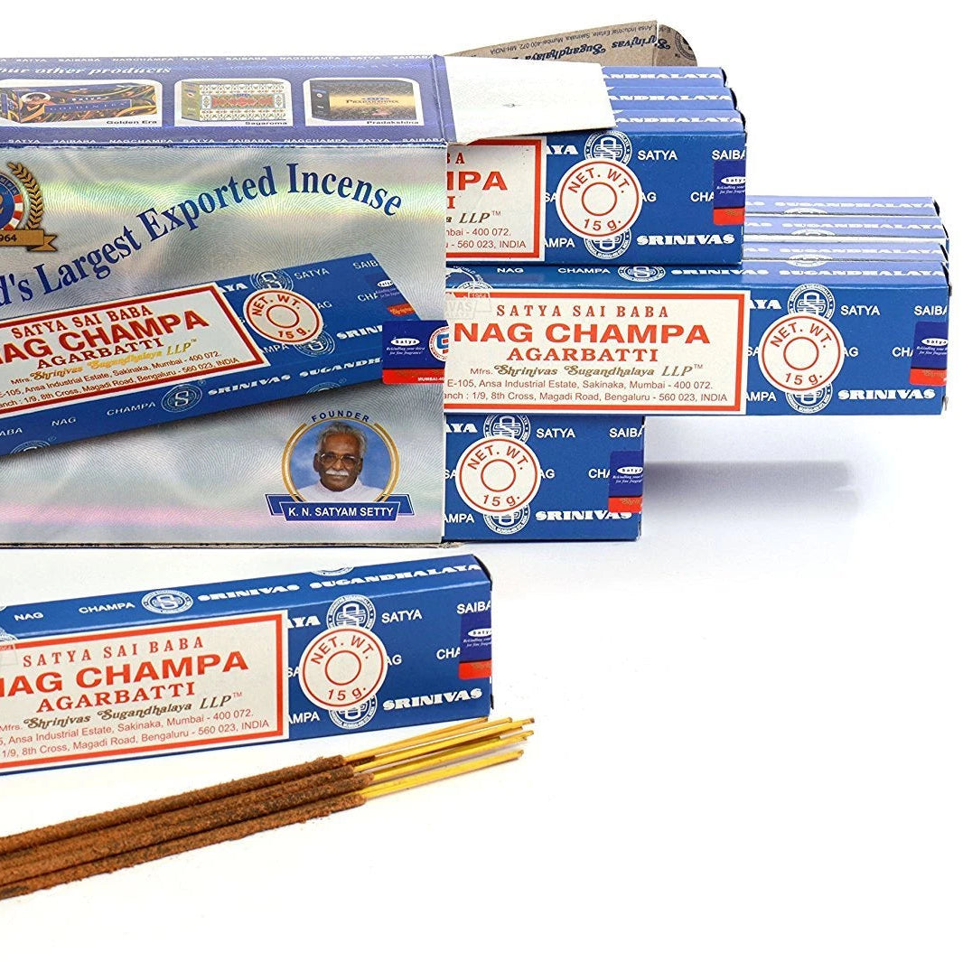 Multiple boxes and packets of Nag Champa incense with sticks on a white background