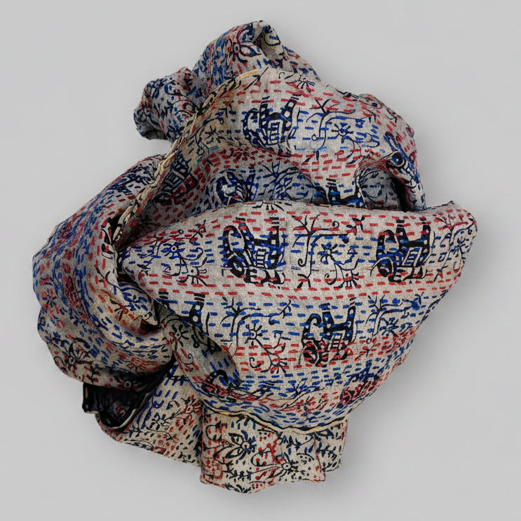 Folded scarf with intricate patterns on a textured beige background