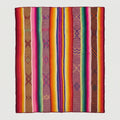 A colorful woven area rug with vertical stripes in pink, orange, yellow, green, blue, purple, and brown.