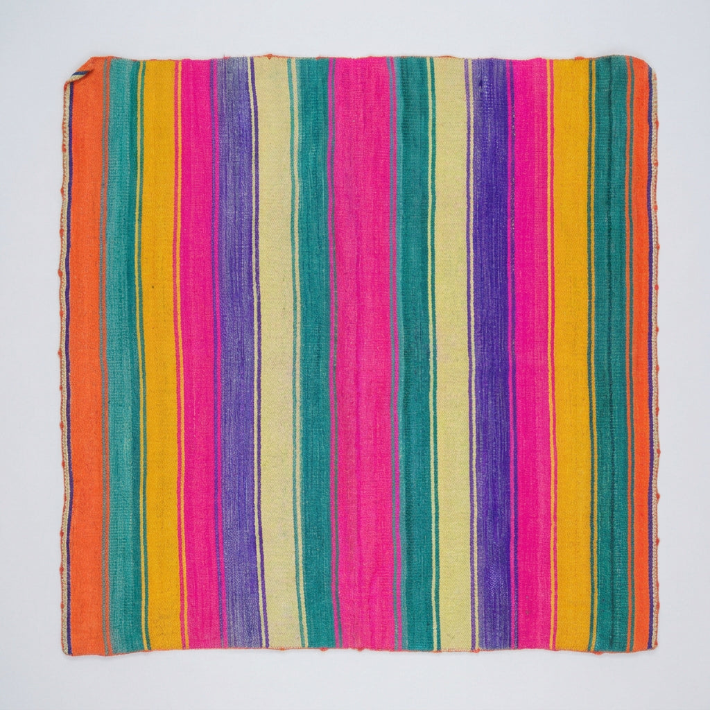 A square multicolor striped blanket or rug with vertical bands of orange, teal, yellow, cream, pink, purple, and blue.