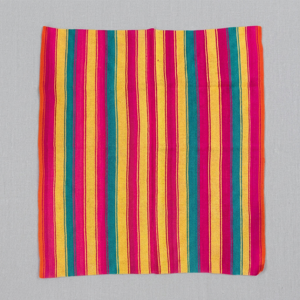 A square textile item,  a blanket,rug, featuring a vibrant vertical stripe pattern in yellow, magenta, orange, and teal.
