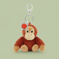 Plush orangutan keychain with a rose charm on a white background