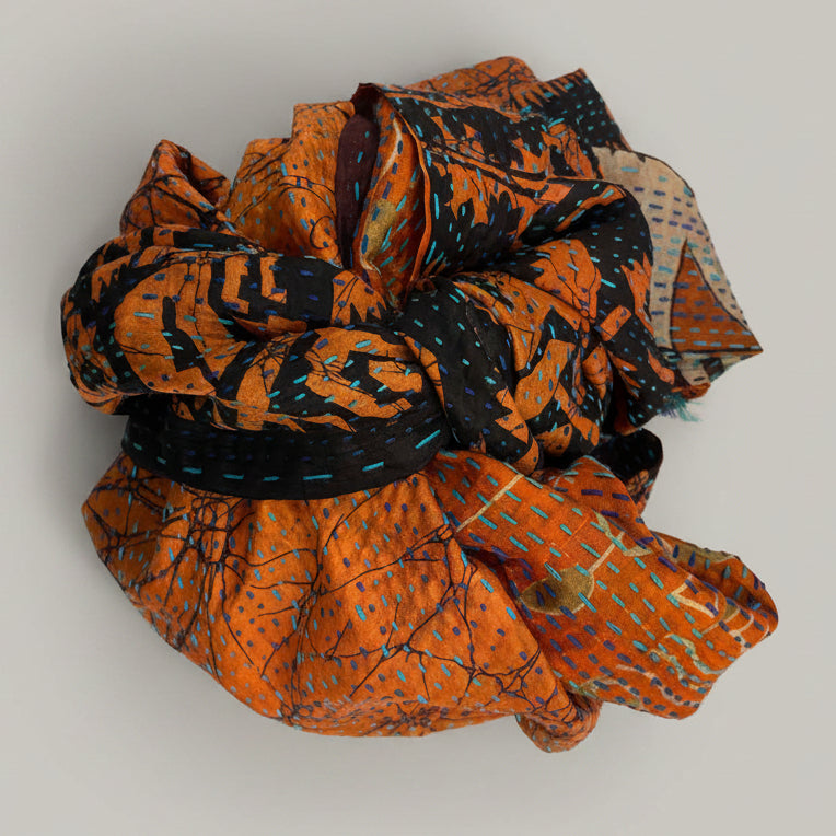 Fabric scarf with orange and black patterns on a beige background