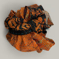 Fabric scarf with orange and black patterns on a beige background