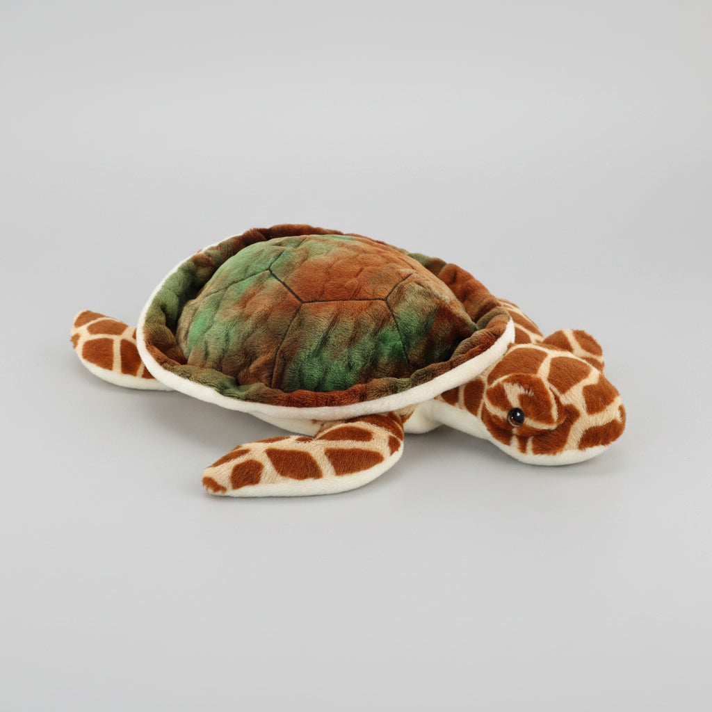 Plush toy sea turtle with giraffe pattern on a white background