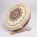 Decorative drum with mandala design and mallet on a white background