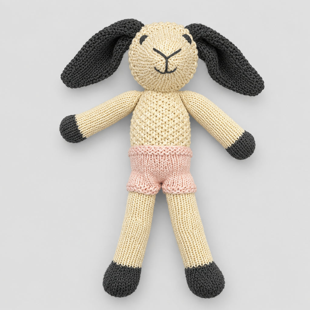 crochet sheep with long black ears and pink shorts