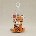 Plush tiger keychain with a silver ring and red emblem on a white background