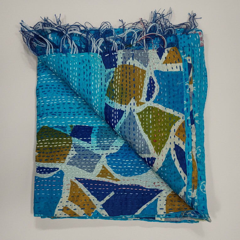Folded scarf with blue and multicolor pattern on a grey background