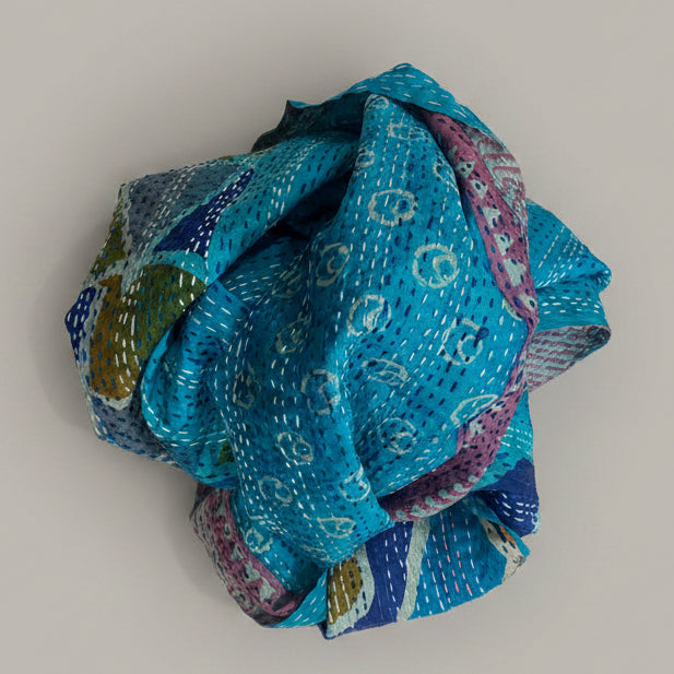 Folded blue scarf with pattern on a beige background