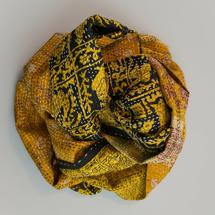 A yellow and gold silk sari scarf with floral patterns, displayed on a neutral background.