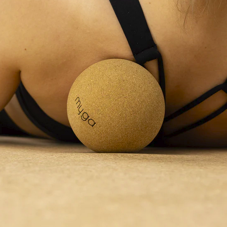 A beige cork yoga ball with the brand name 'myga' printed on the front.