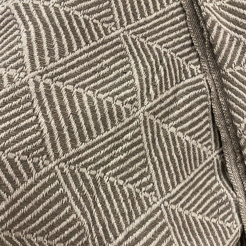 Close-up of a woven textile with a geometric basketweave pattern in taupe and off-white.